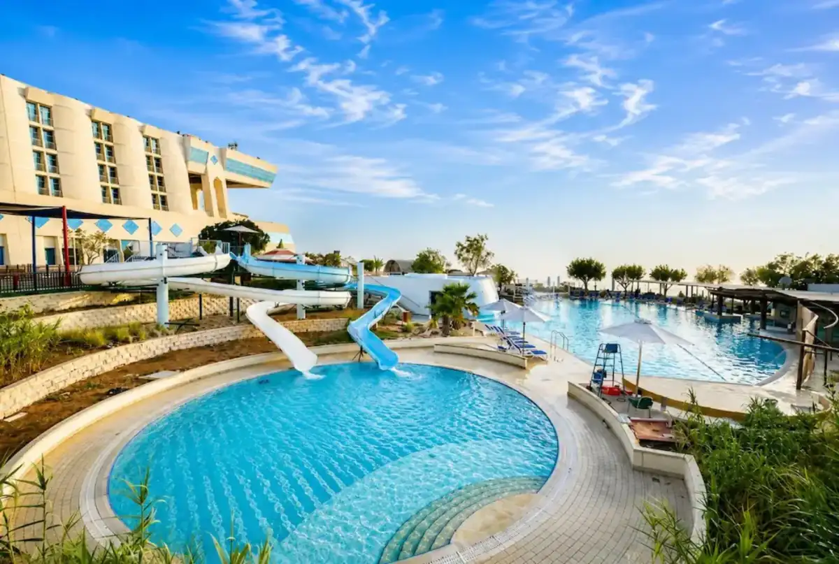 Outdoor swimming pool with water slides and mountain views